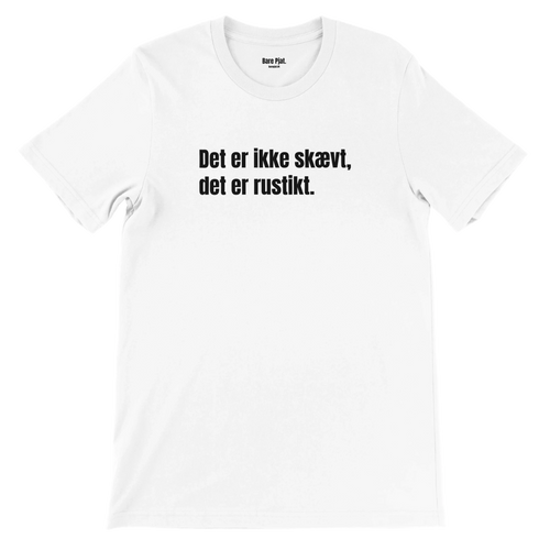 Hvid t-shirt med teksten ”Det er ikke skævt, det er rustikt.”