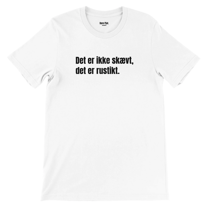 Hvid t-shirt med teksten ”Det er ikke skævt, det er rustikt.”